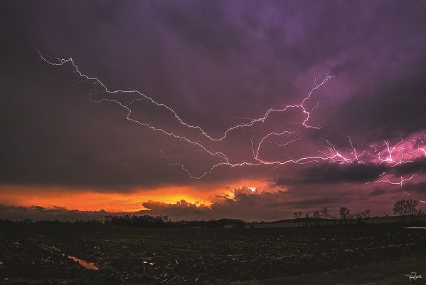 Lightning at sunset across rural Wisconsin farmland