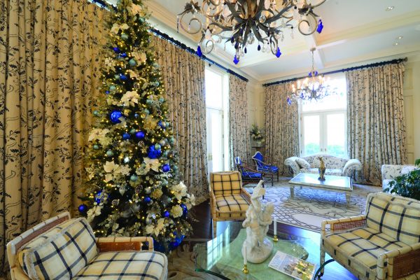 GLANWORTH GARDENS: The Victoria Old World theme is carried through to the loggia with its Christmas tree that combines blue and white ornaments that coordinate to match the predominate color scheme of the room.