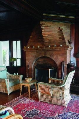 The massive brickwork fireplace creates an effect like the bow of a ship emerging from the west wall of the cozy living room.