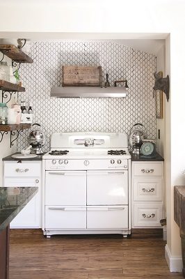 In the kitchen, a 1940s stove is set off by a contemporary backsplash and shelving made from the home’s original floorboards, offering spots to display interesting finds. 