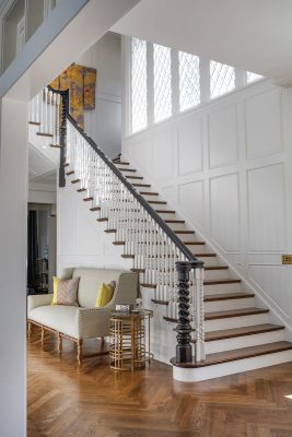The windows in the entry echo the distinctive diamond grid of architect Perkins' original design, and the balusters on the staircase were hand-cut to repeat a triplicate pattern.