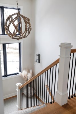 Details like the main stairway’s driftwood light fixture infuse a calm, coastal aesthetic.