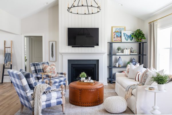 In the living room, walls painted in Sherwin-Williams Origami White and vertical tongue-and-groove paneling around the fireplace provide a soothing backdrop for layers of vibrant colors and textures.