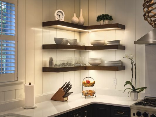 In the kitchen, floating shelves with built-in lighting provide storage and display space.